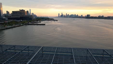 Aerial-view-of-the-Hudson-river-and-the-Hudson-Yards-skyline,-dusk-in-New-York-City---pan,-drone-shot