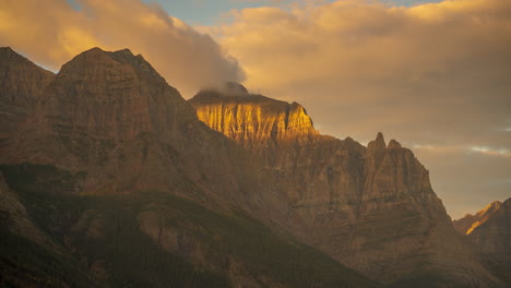 Time-Lapse,-Golden-Sunlight-on-Rocky-Mountain-Peaks,-Cliffs-and-Clouds