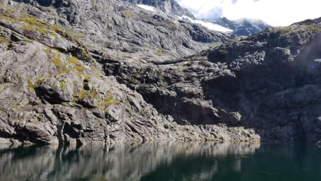Neigung-Eines-Natürlichen-Sees,-Der-Im-Sommer-Von-Felsigen-Bergen-Umgeben-Ist---Gertrude-Saddle,-Neuseeland