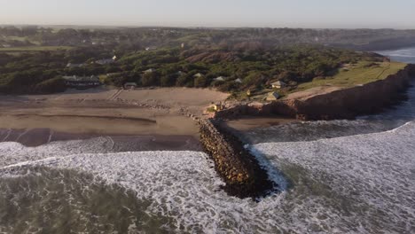 Aerial-drone-footage-of-beautiful-Argentinian-coastline-with-sandy-Luna-Roja-Beach-during-sunset-in-Chapadmalal-,Argentina