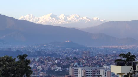 Un-Lapso-De-Tiempo-De-Día-A-Noche-Sobre-La-Ciudad-De-Katmandú-Con-Las-Montañas-Del-Himalaya-Al-Fondo