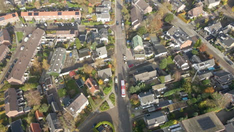 Aerial-of-bus-driving-through-a-suburban-neighborhood-and-stopping