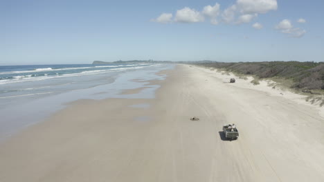 4K-Drohnenaufnahme-Eines-Autos,-Das-Entlang-Des-Wunderschönen-Strandes-In-Australien-Fährt