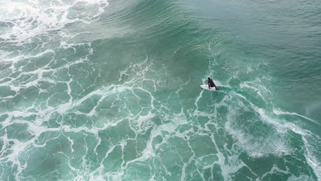 4k-Drone-shot-of-a-extreme-sport-surfer-riding-a-big-blue-ocean-wave-at-Lennox-Head,-Australia
