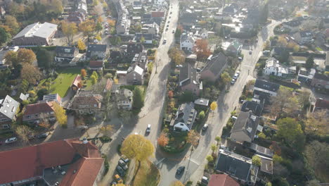 Aerial-of-cars-driving-over-streets-in-a-beautiful-suburban-neighborhood-in-autumn