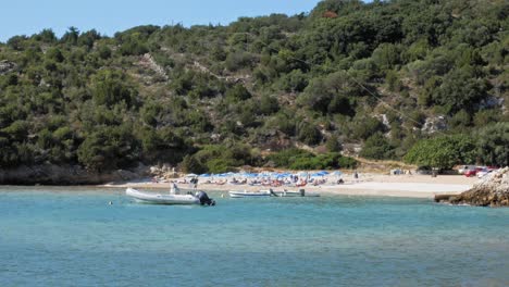 Beautiful-Tropical-Beach-With-People-Lying-Relaxed-On-Sunbeds-Enjoying-The-Sunny-Day-At-Jerusalem-Beach-In-Kefalonia,-Greece
