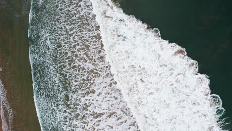 Aerial-footage-of-breaking-waves,-top-down-view