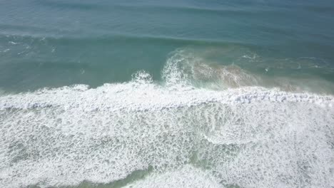 aerial-view-of-ocean-with-some-waves-and-green-colours