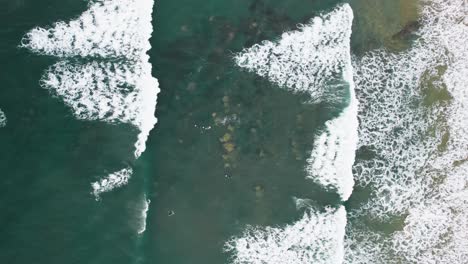 Top-down-view-on-surfers-and-rolling-waves