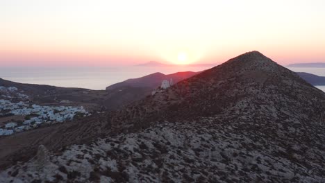 Aerial-flying-mountain-hill-towards-Picturesque-Panagia-Church-at-Stunning-Sunset,-Folegandros-Island