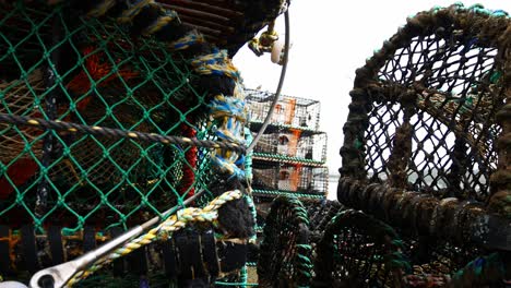 Gestapelte-Leere-Fischereiindustrie-Hummernetzmaschenkörbe-Nahaufnahme-Dolly-Rechts