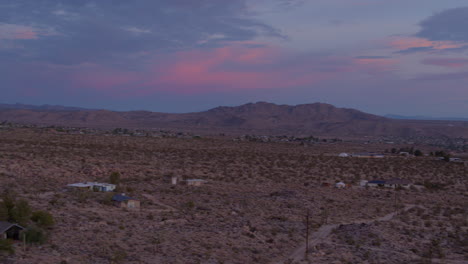 Panoramic-aerial-view-of-desert-landscape-with-houses-at-sunset-in-Joshua-Tree,-California