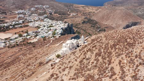 Luftfliegen-Durch-Panagia-Kirche-Bergauf-Und-Folegandros-Dorfhintergrund,-Griechenland