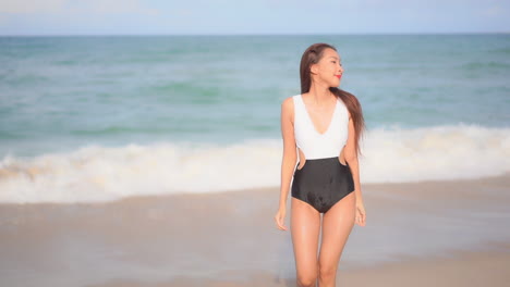 Schöne-Thailändische-Frau,-Die-An-Einem-Sonnigen-Tag-Mit-Badeanzug-Aus-Dem-Meer-Geht,-Freizeit-Am-Strand