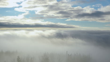 Niebla-Que-Avanza-Sobre-El-Bosque-Y-Las-Colinas-Circundantes-Durante-Una-Tarde-Soleada