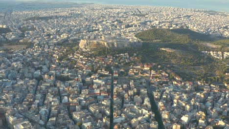 Volando-Alto-Amplio-Panorama-De-La-Ciudad-De-Atenas-Hacia-El-Icónico-Templo-De-La-Acrópolis,-Grecia