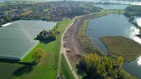 Aerial-drone-view-of-the-landscape-that-reveals-greenhouses-and-beautiful-lakes-in-the-Netherlands,-Europe
