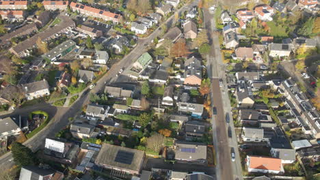 Aerial-of-cars-driving-through-a-beautiful-suburban-neighborhood-in-autumn