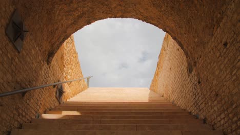 Stone-Steps-Leading-Towards-End-Of-A-Tunnel-Inside-Of-The-Roman-Circus-In-Tarragona,-Spain---low-angle