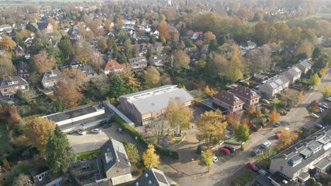 Aerial-of-a-elementary-school-with-children-playing-on-square-on-a-lovely-autumn-day