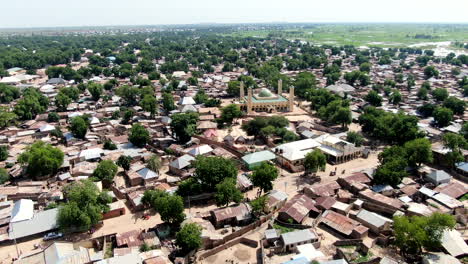 A-shanty-town-suburb-of-Argungu-in-Kebbi-State,-Nigeria-and-the-National-Mosque---ascending-aerial-view