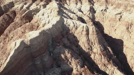 Drohnenaufnahme,-Die-überfliegt,-Während-Die-Kamera-Langsam-über-Eine-Wüstenartige,-Mondähnliche-Landschaft-Irgendwo-Im-Westen-Der-USA-In-4k-Kippt