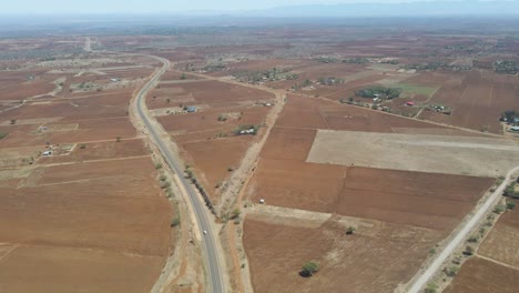 aerial-of-car-driving-over-calm-highway-in-rustic-Kenyan-countryside