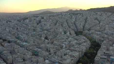 Ascending-shot-over-Athens-Cityscape-endless-buildings-at-sunrise,-Greece