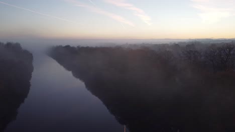 Nebliger-Herbst-Dichter-Nebel-über-Manchester-Schiff-Kanal-Silhouette-Baumkronen-Luftaufnahme-Langsam-Einschieben