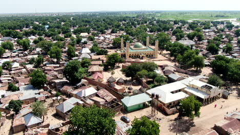 Argungu-Town-and-the-National-Mosque-in-Kebbi-State,-Nigeria---pull-back-aerial-flyover