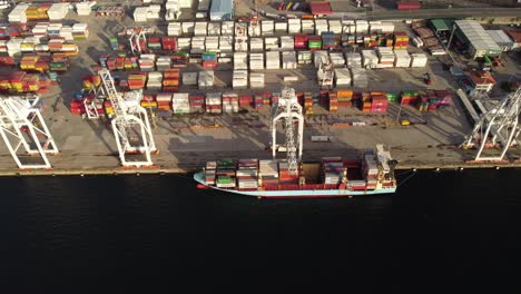 Aerial-view-of-a-shipping-container-cargo-boat-with-crane-working-import-export-food-chain-capitalism-consumerism-concept