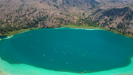 Aerial-pullback-reveal-freshwater-Lake-kournas-water-color-phenom,-Crete-Island