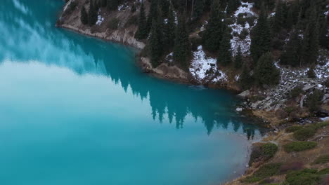 Cinematic-drone-shot-of-the-turquoise-colored-lake-water-at-Big-Almaty-Lake-in-the-Trans-Ili-Alatau-mountains-in-Kazakhstan