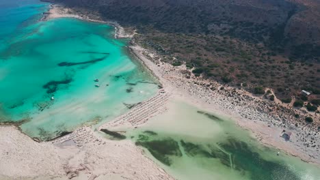 Descending-Top-down-view-Beautiful-clear-turquoise-Sea-at-touristic-Balos-Beach,-Crete-Island