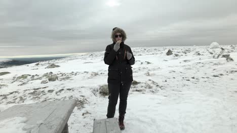 Women-With-Sunglasses-Eating-Hot-Dog-In-Arctic-Snow-Landscape
