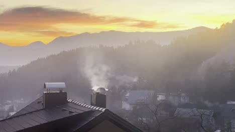 Rauch-Steigt-Aus-Einem-Schornstein-Auf-Einem-Haus-Im-Winter-Mit-Sonnenuntergang-Im-Hintergrund