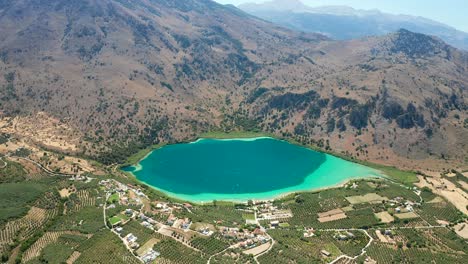 Vista-Panorámica-Aérea-De-Alto-Vuelo-Paisaje-Del-Lago-Kournas,-Fascinantes-Colores-De-Agua,-Grecia
