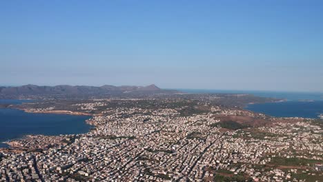Aerial-descending-shot-Chania-Sprawling-City-Centre,-Mountains-Background---Crete-Island