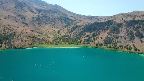 Aerial-Flying-backwards-Natural-freshwater-Lake-Kournas-Landscape,-Crete-island---Greece