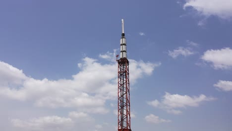 A-communications-tower-against-a-blue-sky-with-scattered-clouds---orbiting-parallax-view