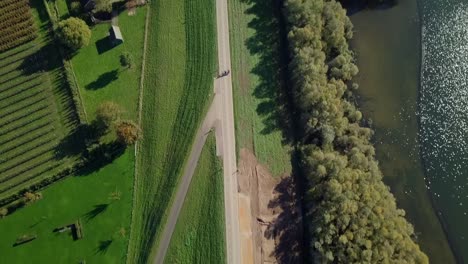 Vista-Aérea-De-Drones-Sobre-La-Hermosa-Carretera-Que-Revela-El-Hermoso-Lago-E-Invernaderos-En-Los-Países-Bajos,-Europa
