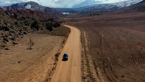 Vista-Aérea-De-Un-Coche-En-Un-Camino-Polvoriento