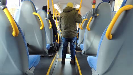 Back-view-of-bus-with-a-man-getting-off-the-bus-and-people-using-public-transport---Handheld-Steady-Shot