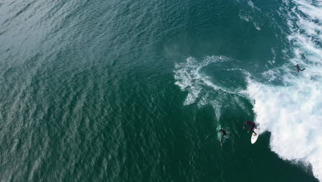 4k-Aerial-shot-of-a-professional-surfer-turning-and-riding-a-big-blue-ocean-wave-at-Lennox-Head,-Australia