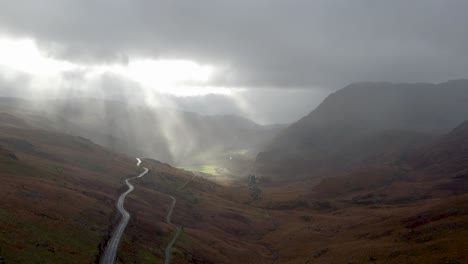 Sunbeams-burst-through-the-clouds-to-show-dramatic-atmosphere-in-Snowdonia-National-Park-Wales