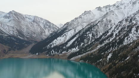 Cinematic-rotating-drone-footage-of-the-turquoise-colored-lake-water-at-Big-Almaty-Lake-in-the-Trans-Ili-Alatau-mountains-in-Kazakhstan