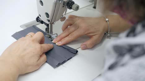 top-down-over-shoulder-shot-of-female-sewing-protective-textile-face-mask-on-machine