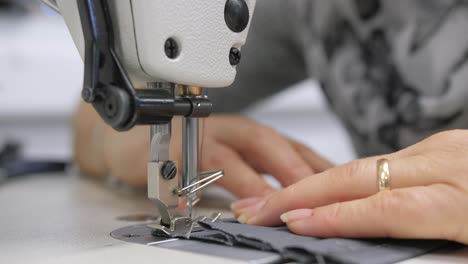 closeup-of-woman-sewing-textile-on-machine,-shallow-depth-of-field,-slow-motion