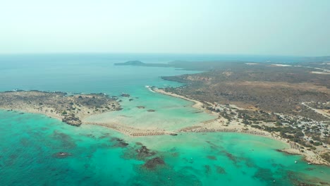 Aerial-view-flying-towards-Sandbanks-and-turquoise-water-at-Elefonissi-beach,-approach-Motion