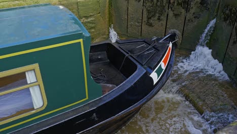 Bow-of-narrowboat-in-canal-lock-system-navigating-to-higher-water-level
